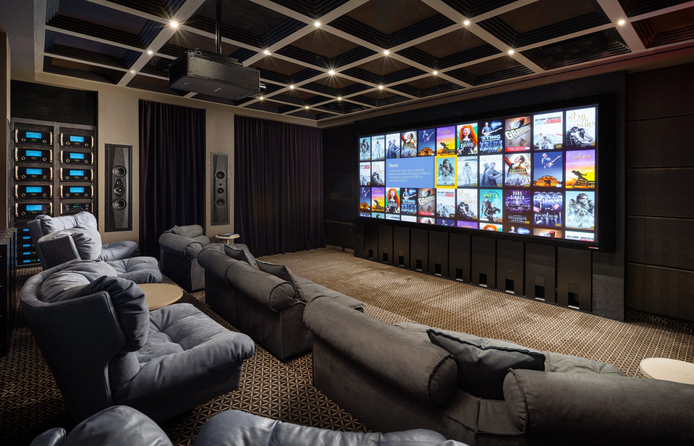 Home theater with multiple screens displaying movie posters, surrounded by comfortable seating.