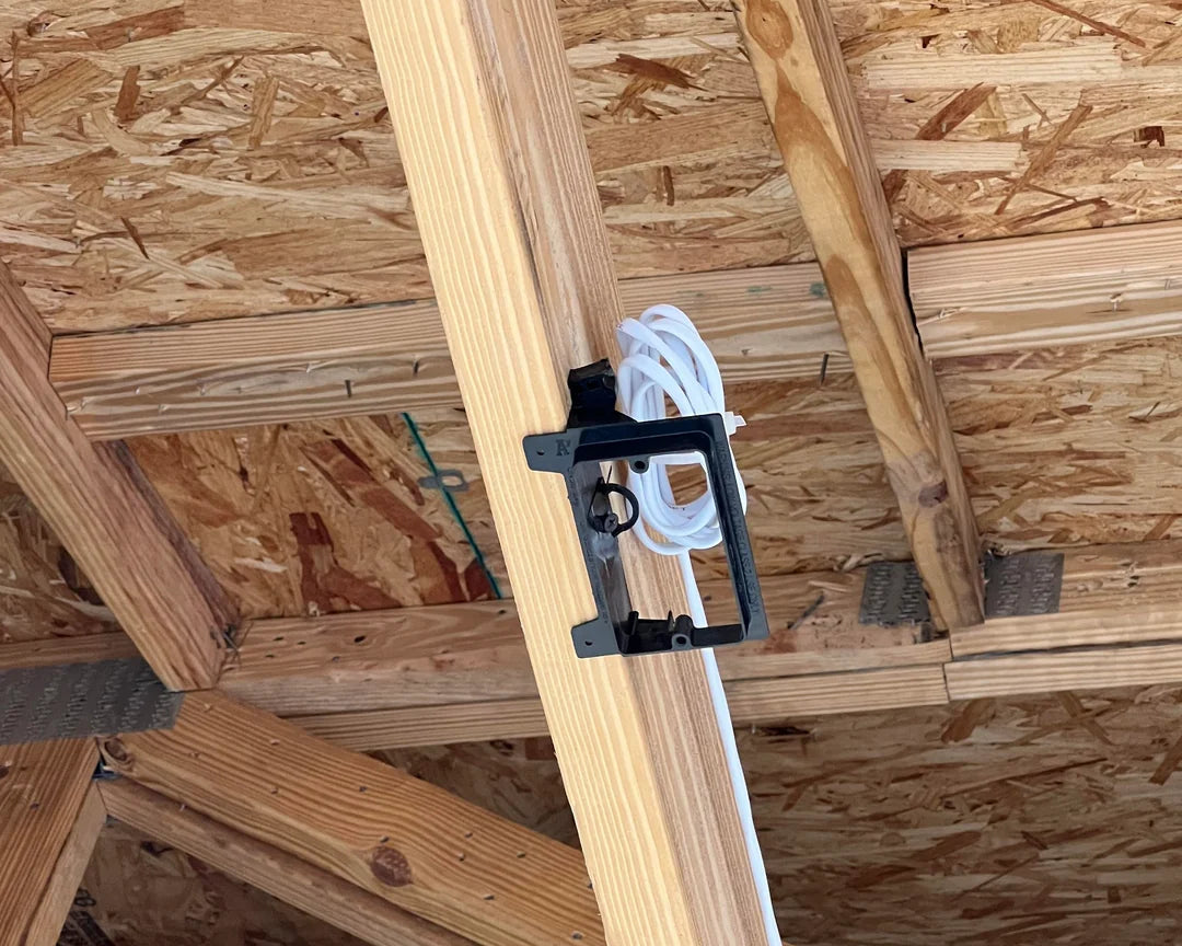 Wooden beams with a white cable and black clip against a wooden wall background
